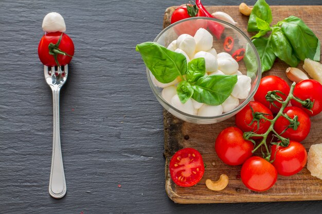 Caprese salad ingredients on dark stone background