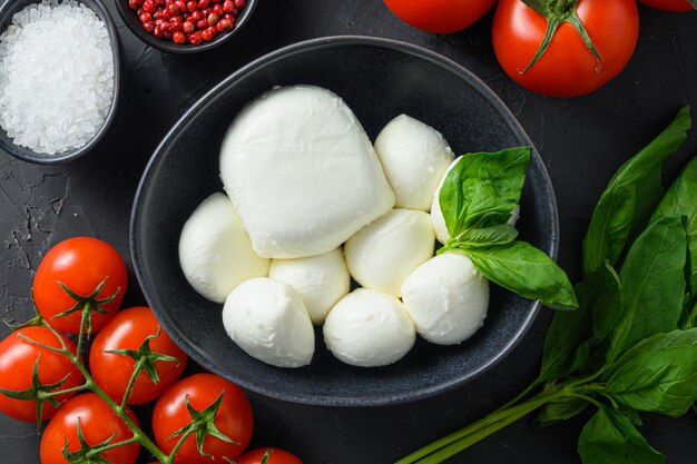 Foto ingredienti insalata caprese palline di mozzarella, bufala, pomodori, foglie di basilico, olio d'oliva con aceto