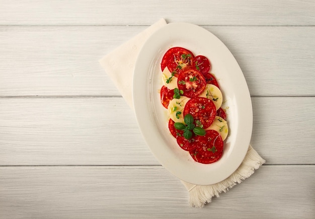 Insalata caprese piatto tradizionale italiano pomodori con mozzarella basilico e spezie vista dall'alto senza persone