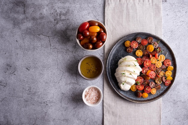 Caprese salad, plate with mozzarella ball and chopped tomatoes.