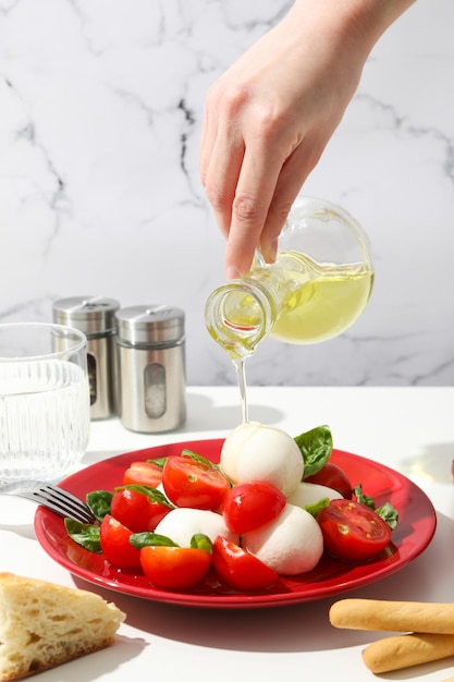 Caprese salad in a red bowl on a light background
