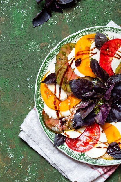 Caprese salad Tomato and mozzarella slices with basil leaves