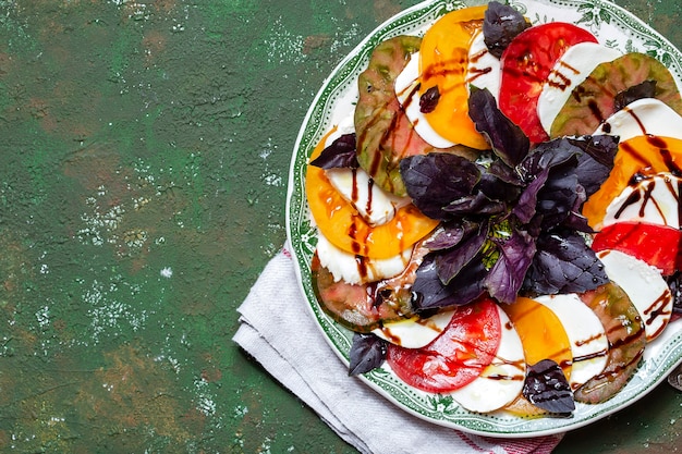 Insalata caprese fette di pomodoro e mozzarella con foglie di basilico