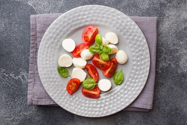 Caprese salad of tomatoes, mozzarella cheese and Basil. Italian cuisine.