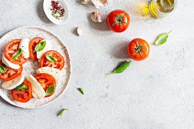 맛있고 건강한 애피타이저를 위한 즙이 많은 토마토 신선한 모짜렐라와 페스토 컨셉을 곁들인 카프레제 샐러드