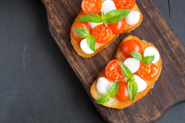 Caprese salad with ripe tomatoes and mozzarella with fresh Basil leaves. Italian food.