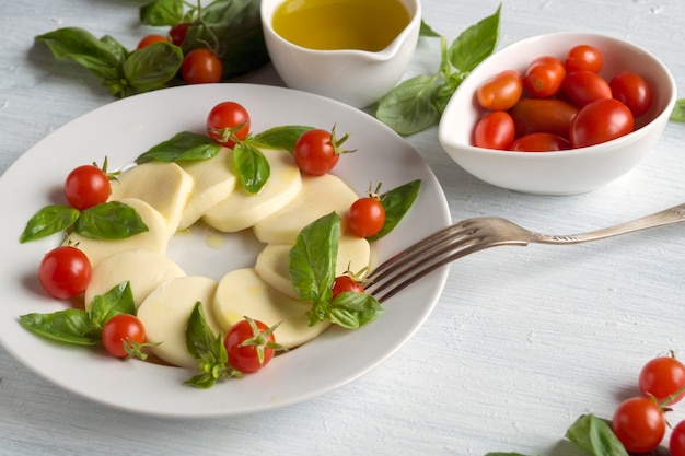 Caprese salad with ripe tomatoes and mozzarella with fresh Basil leaves. Italian food.