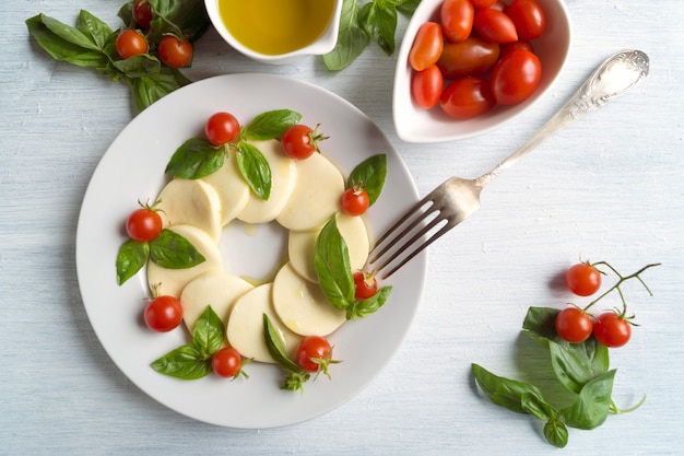 Insalata caprese con pomodori maturi e mozzarella con foglie di basilico fresco. cibo italiano.