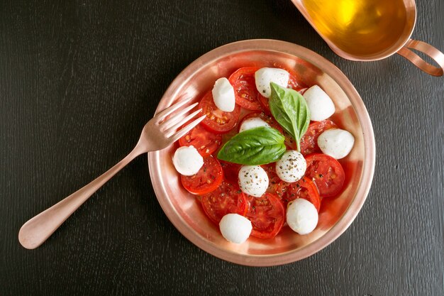 Caprese salad with ripe tomatoes and mozzarella with fresh Basil leaves. Italian food.