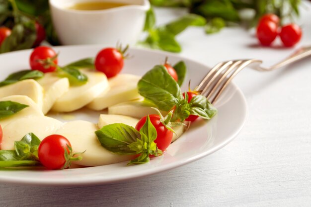 Caprese salade met rijpe tomaten en mozzarella met verse basilicumbladeren. Italiaans eten.