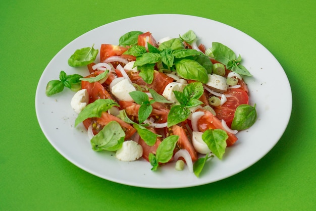 Caprese salade met verse groene basilicum blaadjes tomaten ui en mozzarella kaas