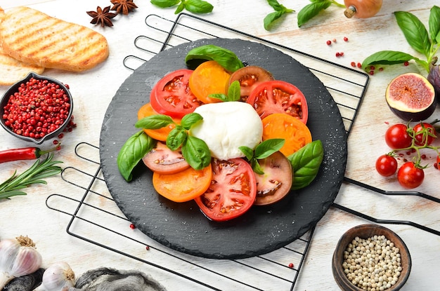 Caprese salade met verse tomaten, mozzarella kaas en basilicum. Italiaans eten. Bovenaanzicht.