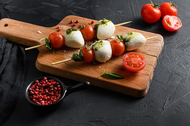 Caprese salade mozzarella plakjes met basilicum blaadjes op stokjes spies