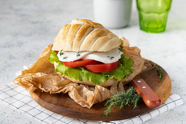 Foto panino caprese su vassoio in legno