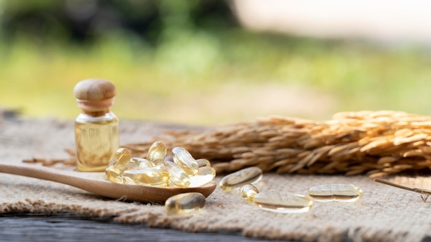 Capsula di olio di granaio di riso in un cucchiaio di legno con olio di granaio di riso pressato a freddo. ricco di grassi buoni, vitamina e,