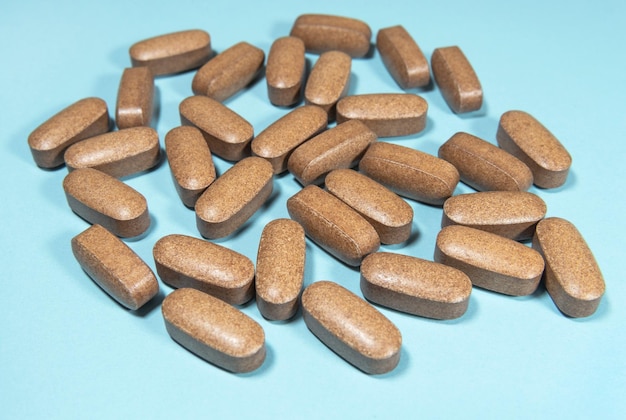 Photo capsules of food supplements on blue paper