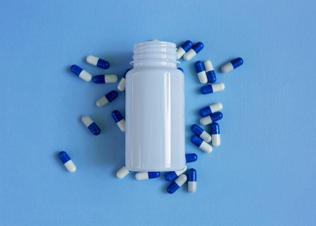 Capsules medication with a jar open in the background