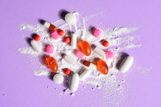 Capsules pills broken with your powder medication on violet background