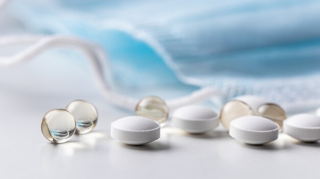 Capsules, pills and medical masks on a white background. Health care, medical, pharmacy and illness concept