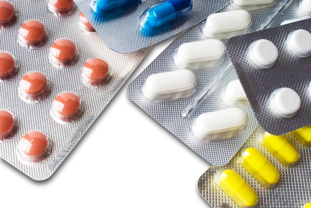 Capsules and pills packed in blister with shadows close-up background