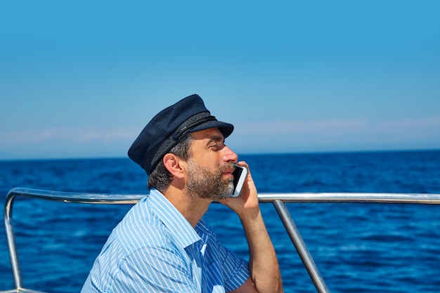 Captain cap sailor man talking mobile phone boat
