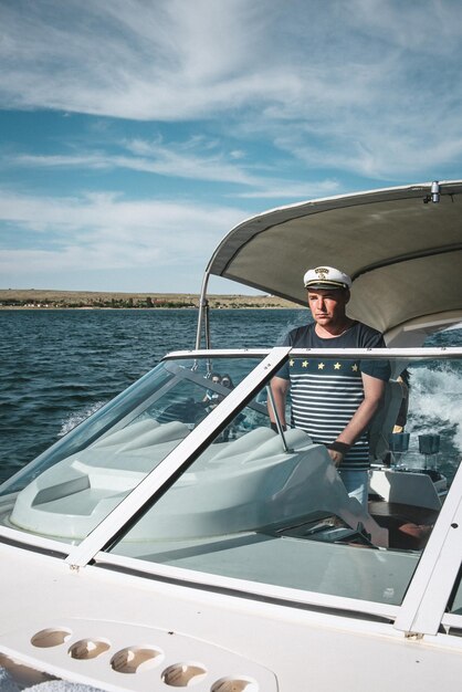 The captain of the yacht at the helm controls the boat on the\
water