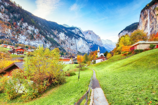 Captivating autumn view of Lauterbrunnen valley with gorgeous Staubbach waterfall and Swiss Alps in the background