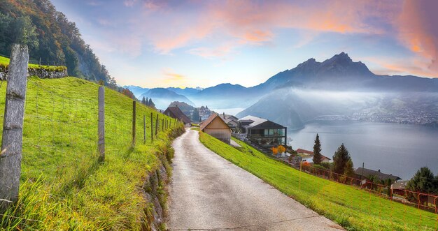 Captivating autumn view on suburb of Stansstad city and Lucerne lake with mountaines and fog