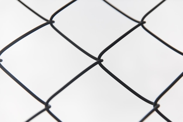 captivity, prison and obstruction concept - close up of mesh fence over gray sky