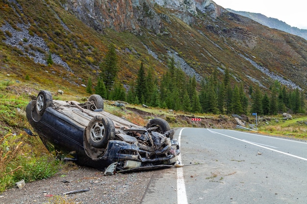 Car accident place on a bend, overturned car lies on the roof