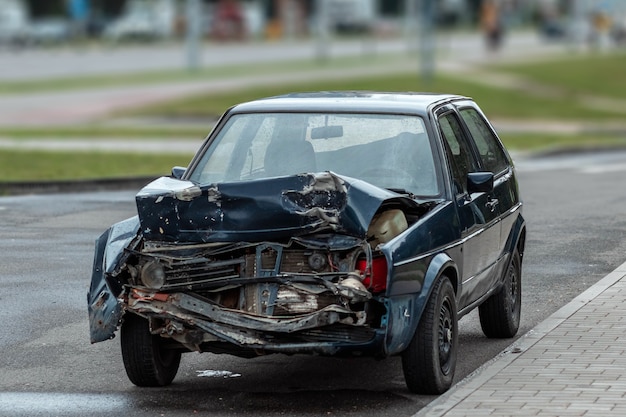 Автомобиль после аварии, крупный план. Сломанный капот, последствия невнимательности на дорогах.