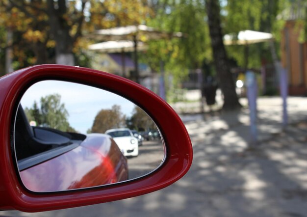 A car approaching from behind is reflected in the side mirror