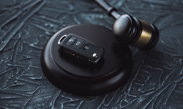 Photo car auction concept - gavel and car key on the wooden desk