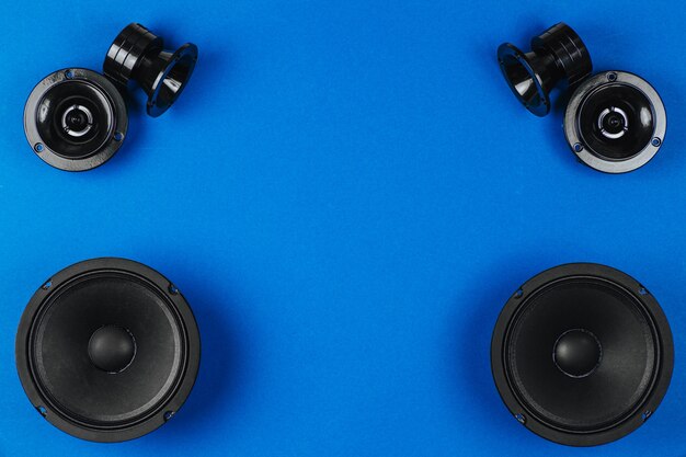 Car audio, car speakers, black subwoofer on a blue background. Copy space