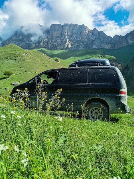 Foto un'auto sullo sfondo del verde paesaggio del passo di aktoprak nel caucaso russia giugno 2021