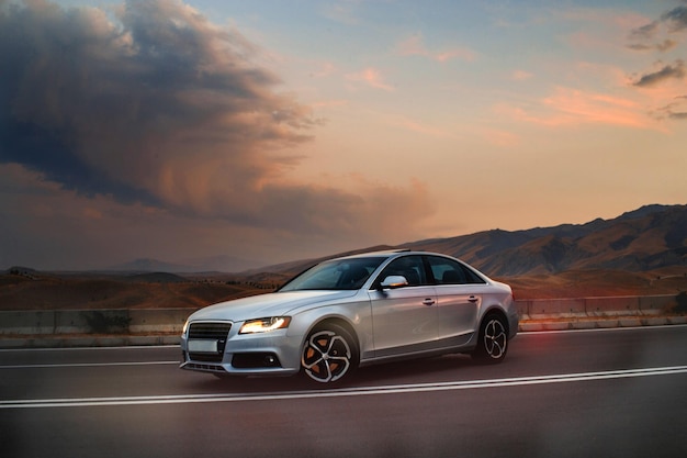 Car on the background of a sunset on a mountain roadl added artificial noisegrain and smoke