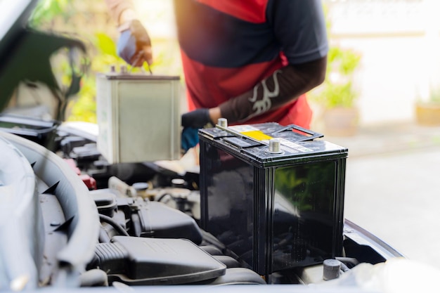 Car battery replacement The car mechanic repairs the car unscrews the battery mount