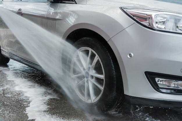 Car being cleaned with water jet