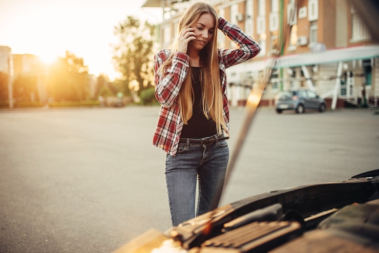 Photo car breakdown, sad woman against open bonnet