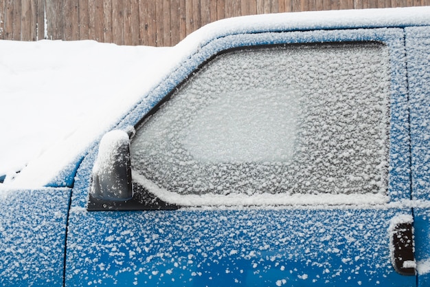 Car cabin window covered by snow