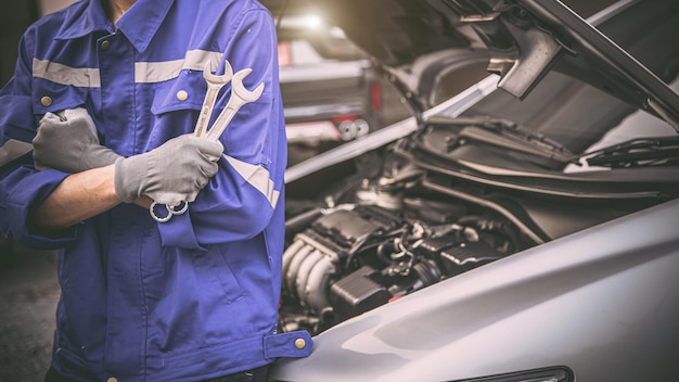 Car care maintenance and servicing Closeup hand technician auto mechanic using the wrench to repairing change spare part car engine problem and car insurance service support