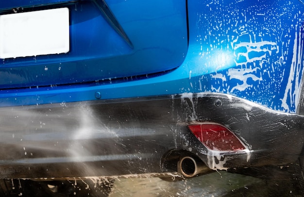Мойка автомобилей струей воды под высоким давлением Синяя мойка автомобилей с белой мыльной пеной Бизнес по уходу за автомобилем