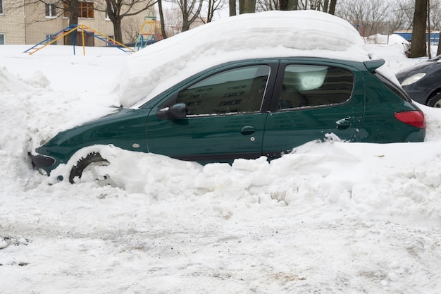 冬の大雪の後、雪の吹きだまりに覆われた車