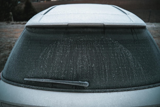 写真 雪に覆われた車の後ろの窓が凍った車の冬