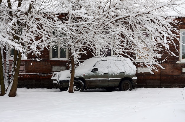 машина покрыта толстым слоем снега.