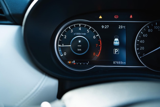 Photo a car dashboard with a fuel gauge showing that the car is low on gas