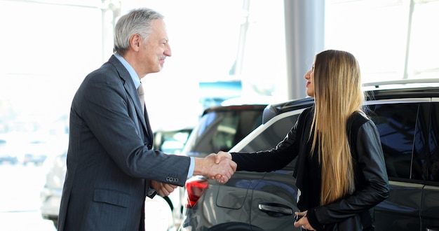 写真 若い女性に握手をする車のディーラー