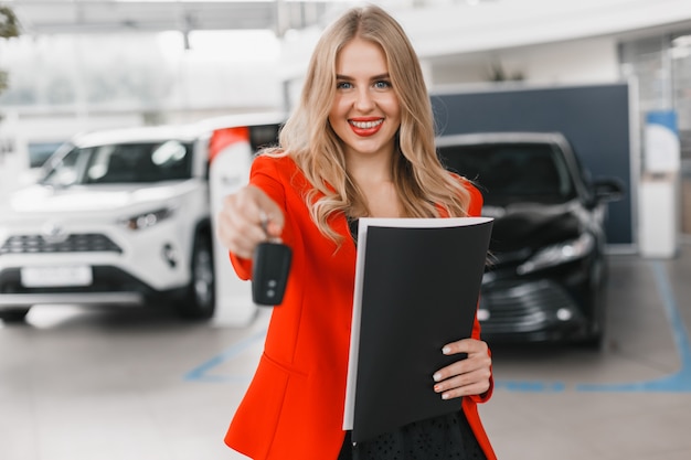 Car dealer giving key on straight arm close up .