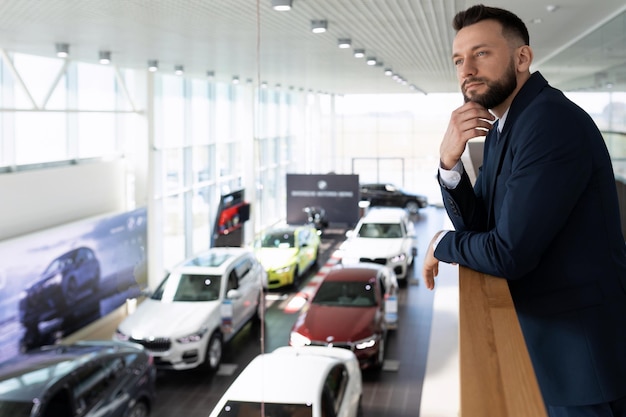 Car dealership owner looking down at his cars