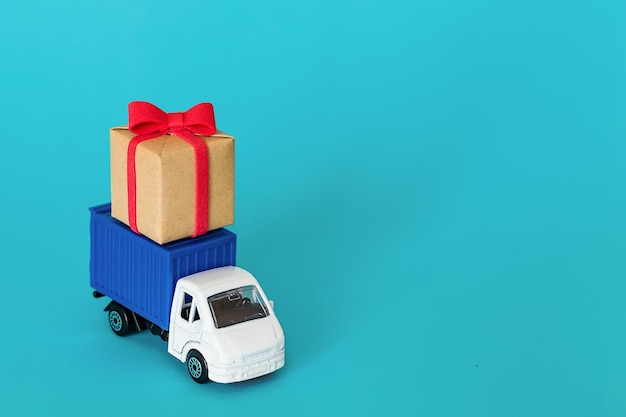 Car delivering gift box for valentine's day on blue background
cargo transportation delivery service transport company
infrastructure and logistics unloading cardboard box place for
text